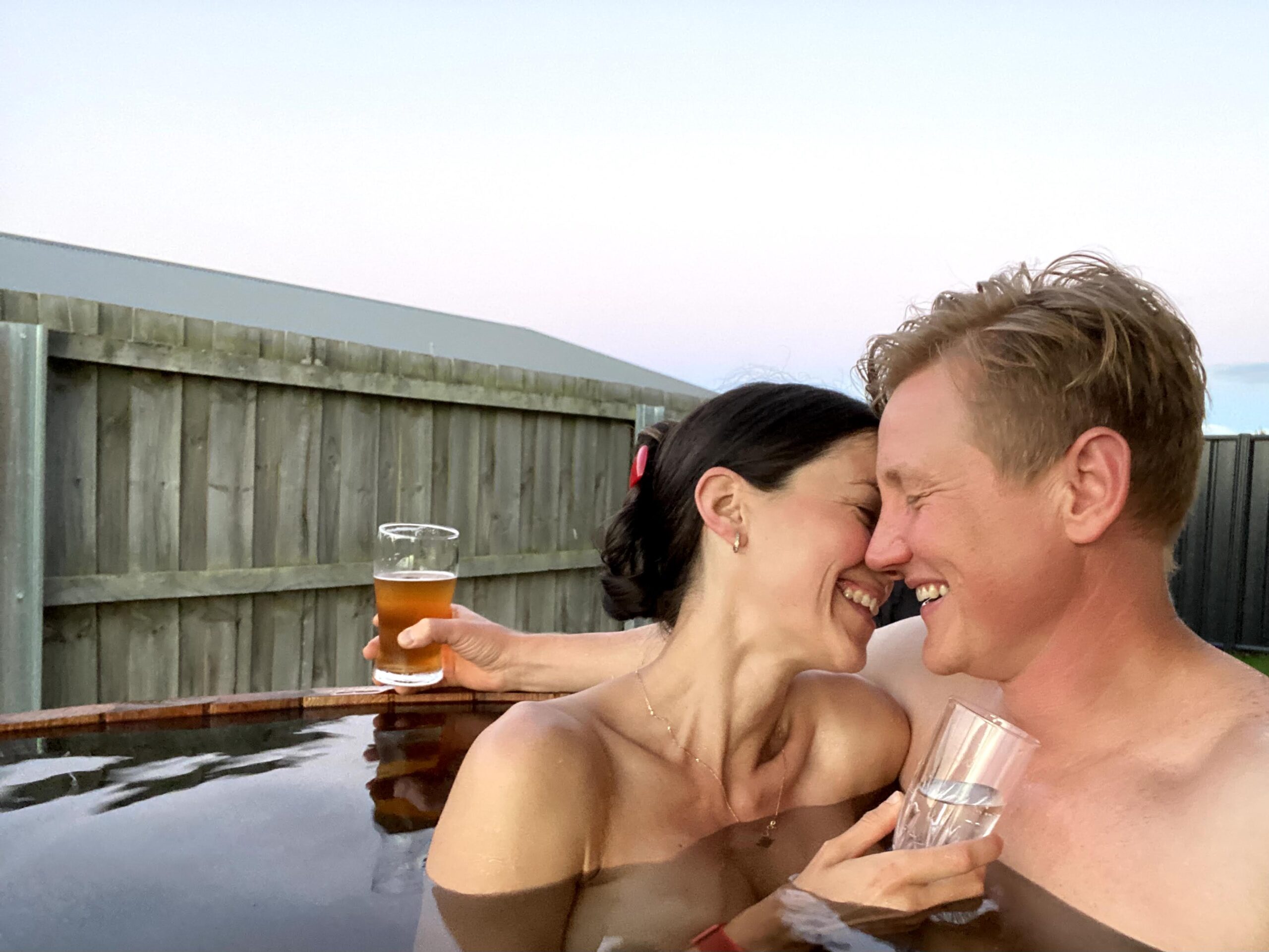 2 people having a good time on a outdoor cedar hot tub