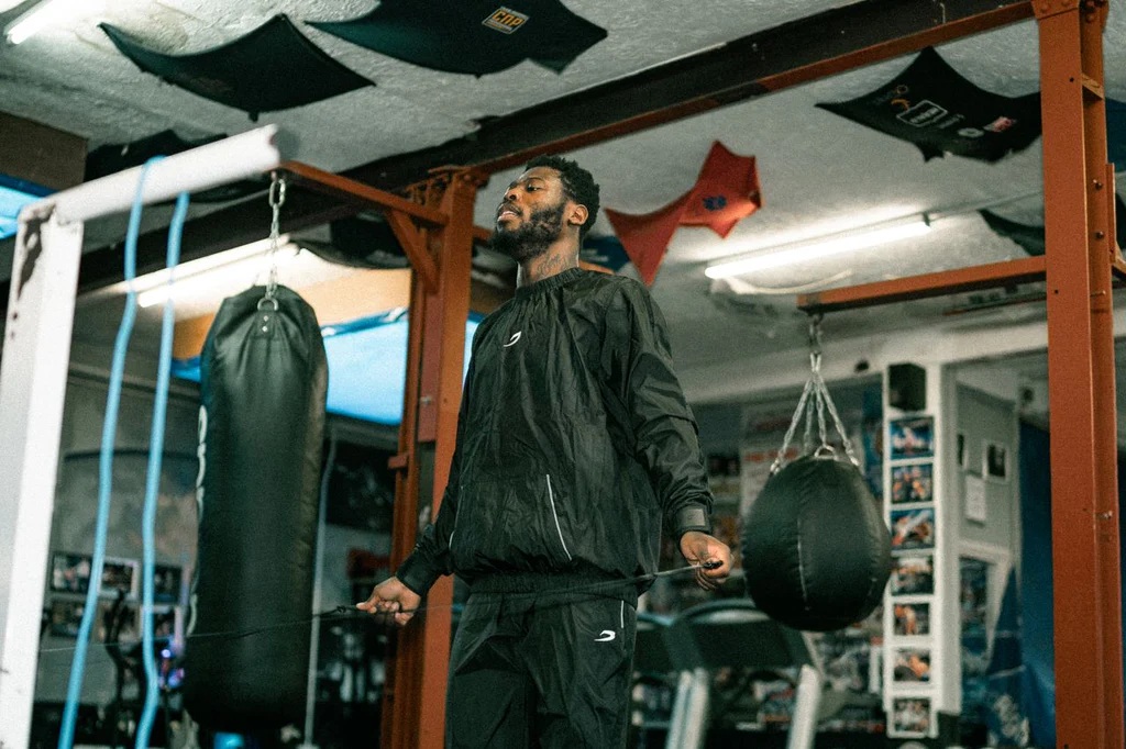 man wearing black sauna suit in gym