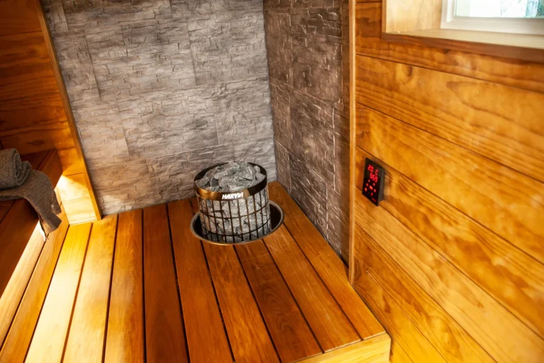 Harvia Cilindro PC90E black steel heater embedded in a sauna bench