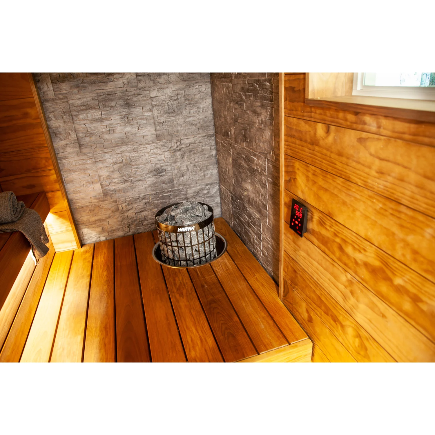 Harvia Cilindro PC90E black steel heater embedded in a sauna bench