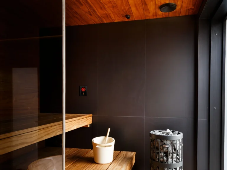 Sauna interior showing the Harvia Fenix FX001XW control panel near the heater
