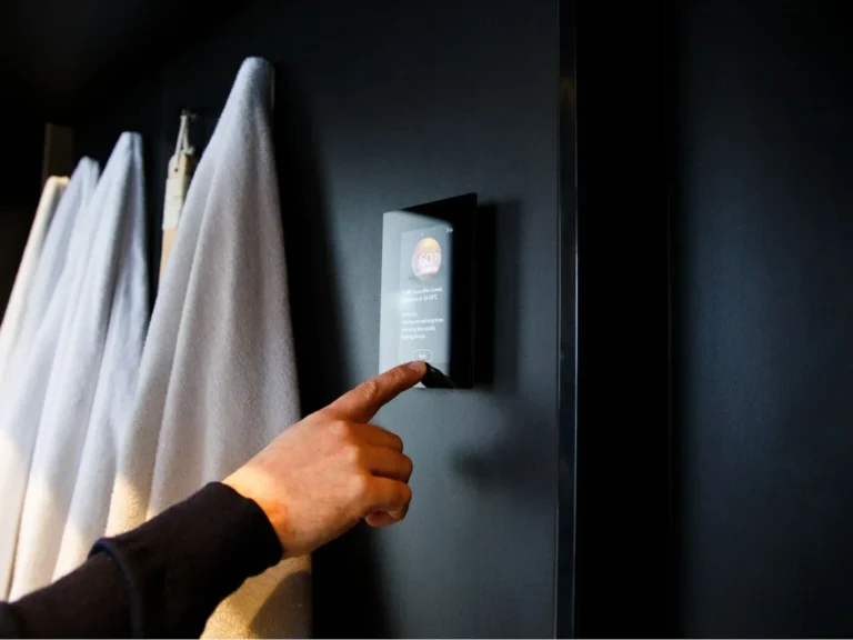 A hand tapping the touchscreen of the Harvia Fenix FX001XW control panel