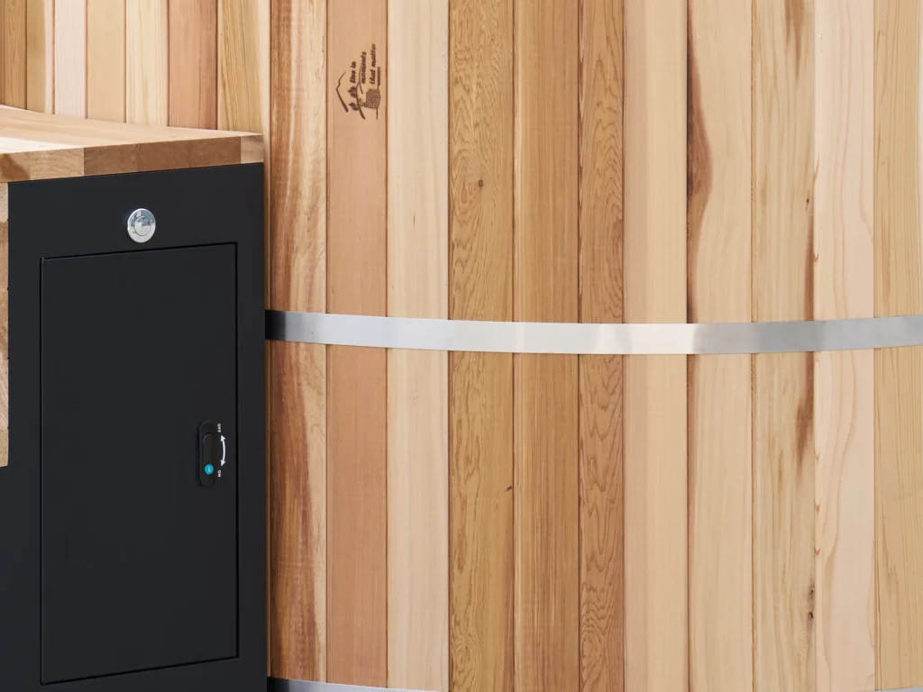 The cedar hot tub beside the steps and equipment cabinet