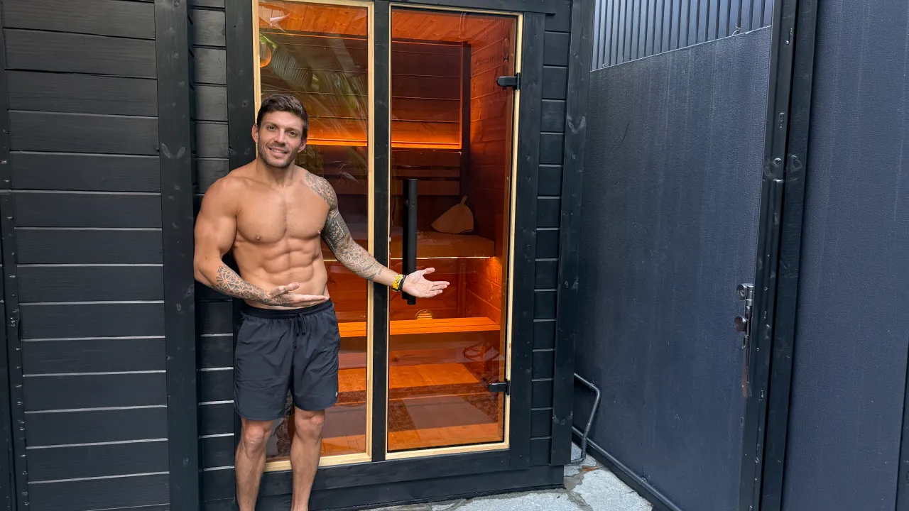 Luke Zocchi standing at the open door of his Leil PATIO outdoor sauna