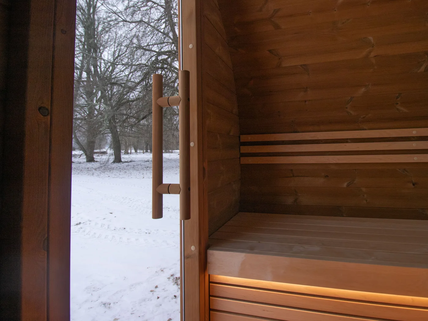 Bench and open door of the Lerra Pure with snow outside