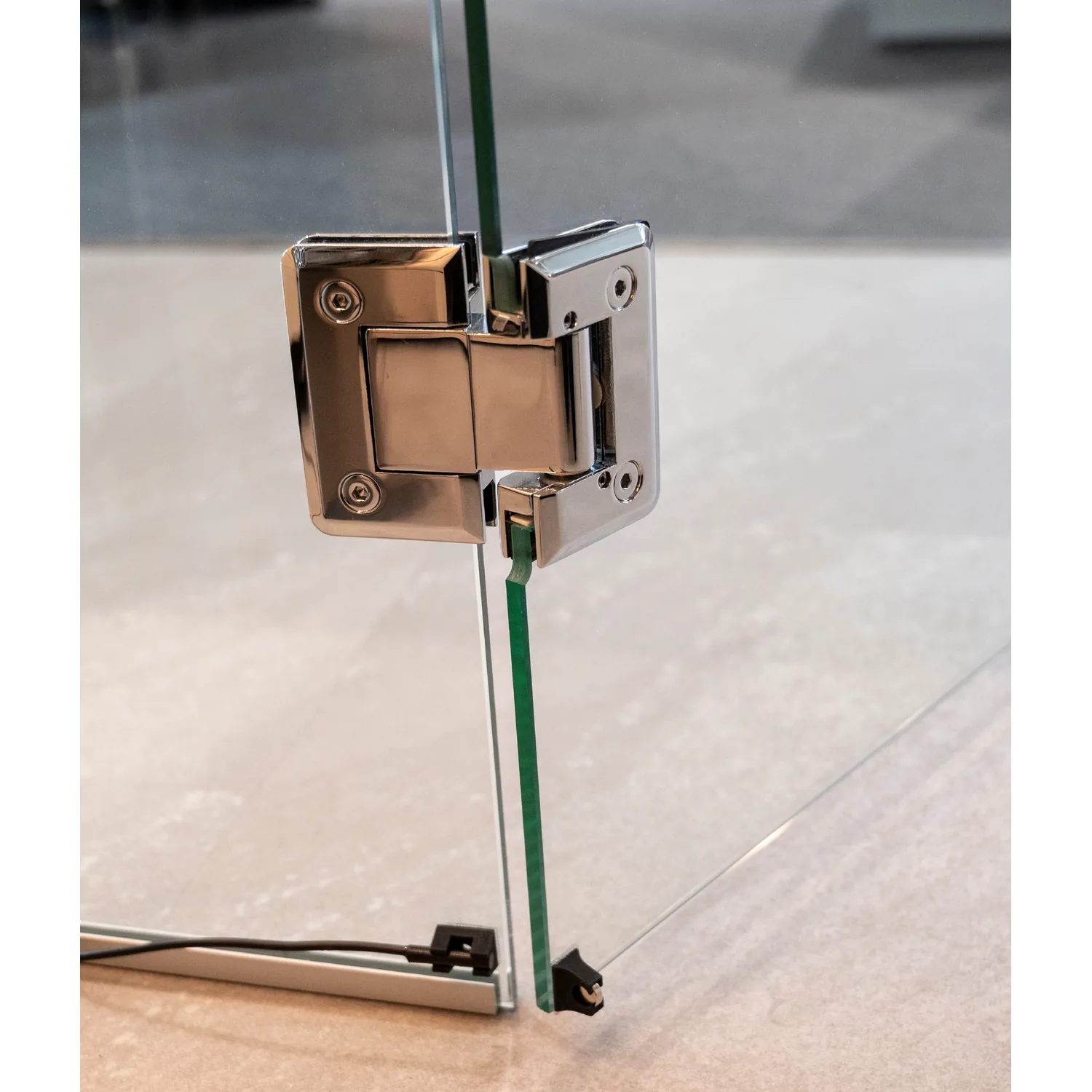 Harvia door sensor mounted below a glass door hinge