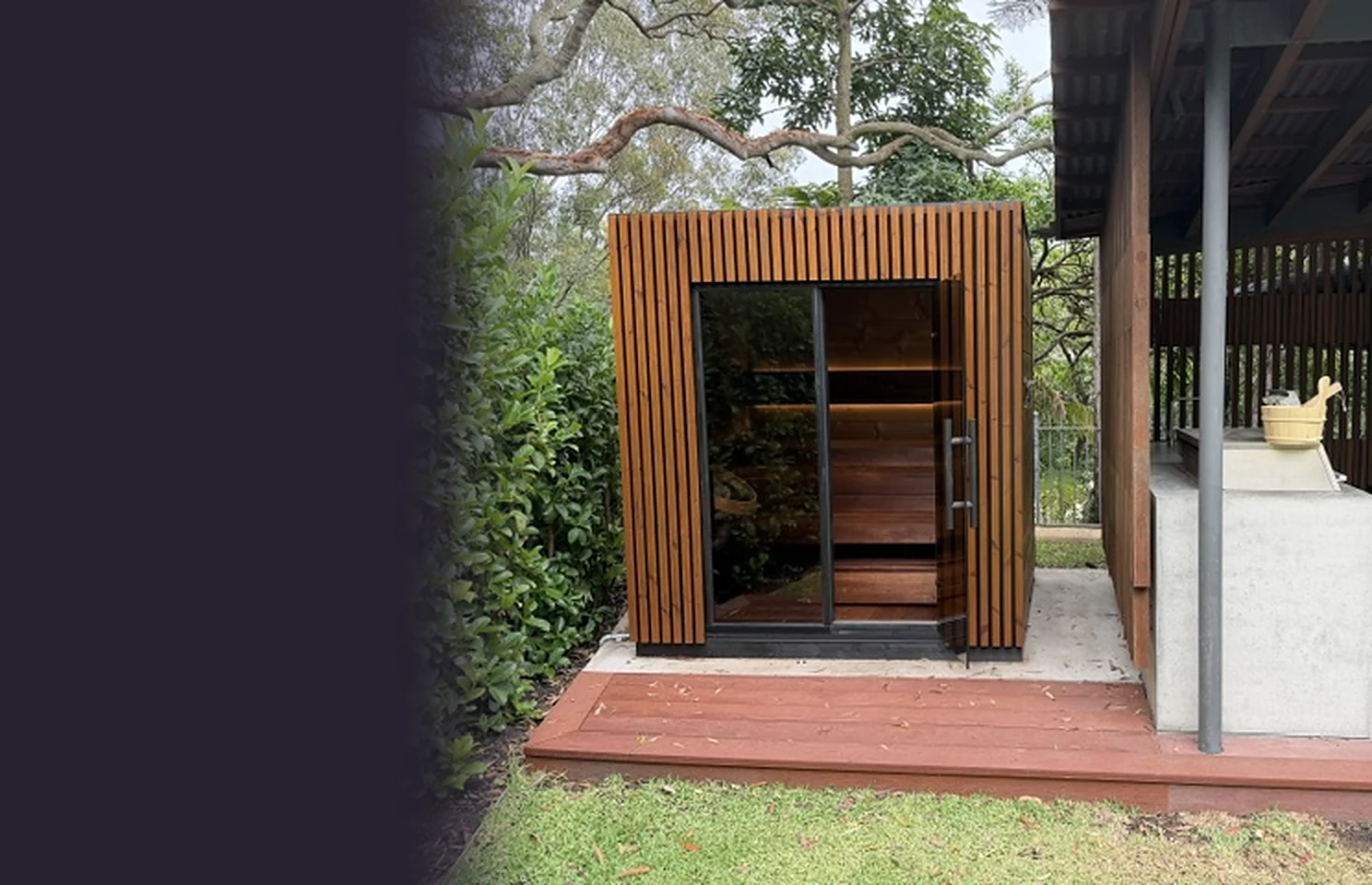 Leil Viva 210 outdoor sauna on a timber deck beside a covered outdoor kitchen, under native trees in Vaucluse, NSW