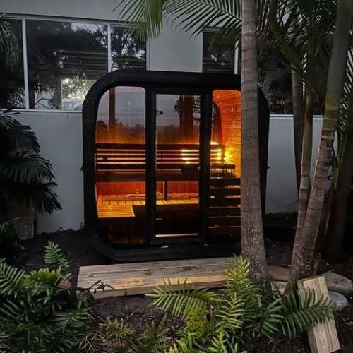 Thermo Treated Spruce UNION 160 outdoor sauna lit at night in tropical garden setting at Eden NSW by Shym Saunas